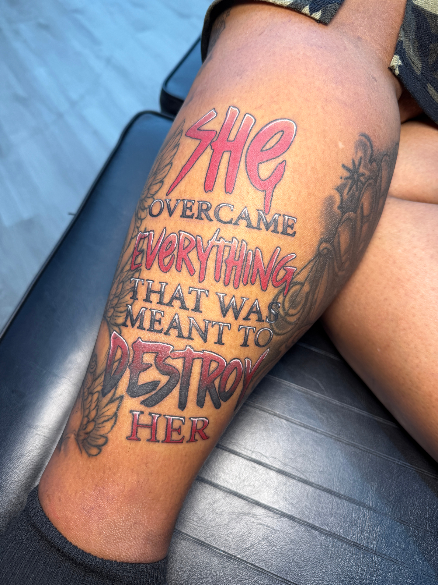Bold script lettering tattoo — 'She overcame everything that was meant to destroy her'