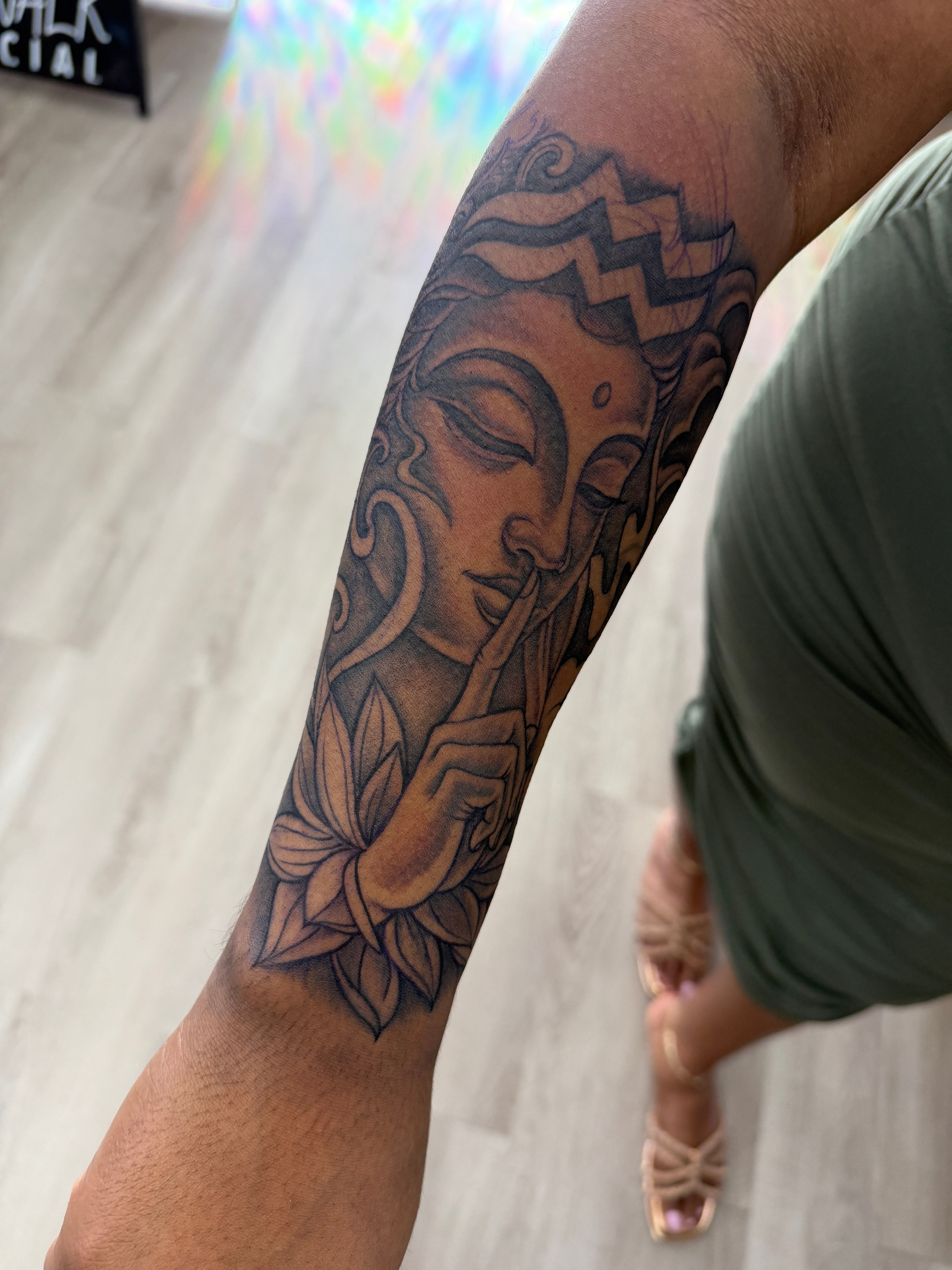Black and grey Buddha and lotus forearm tattoo