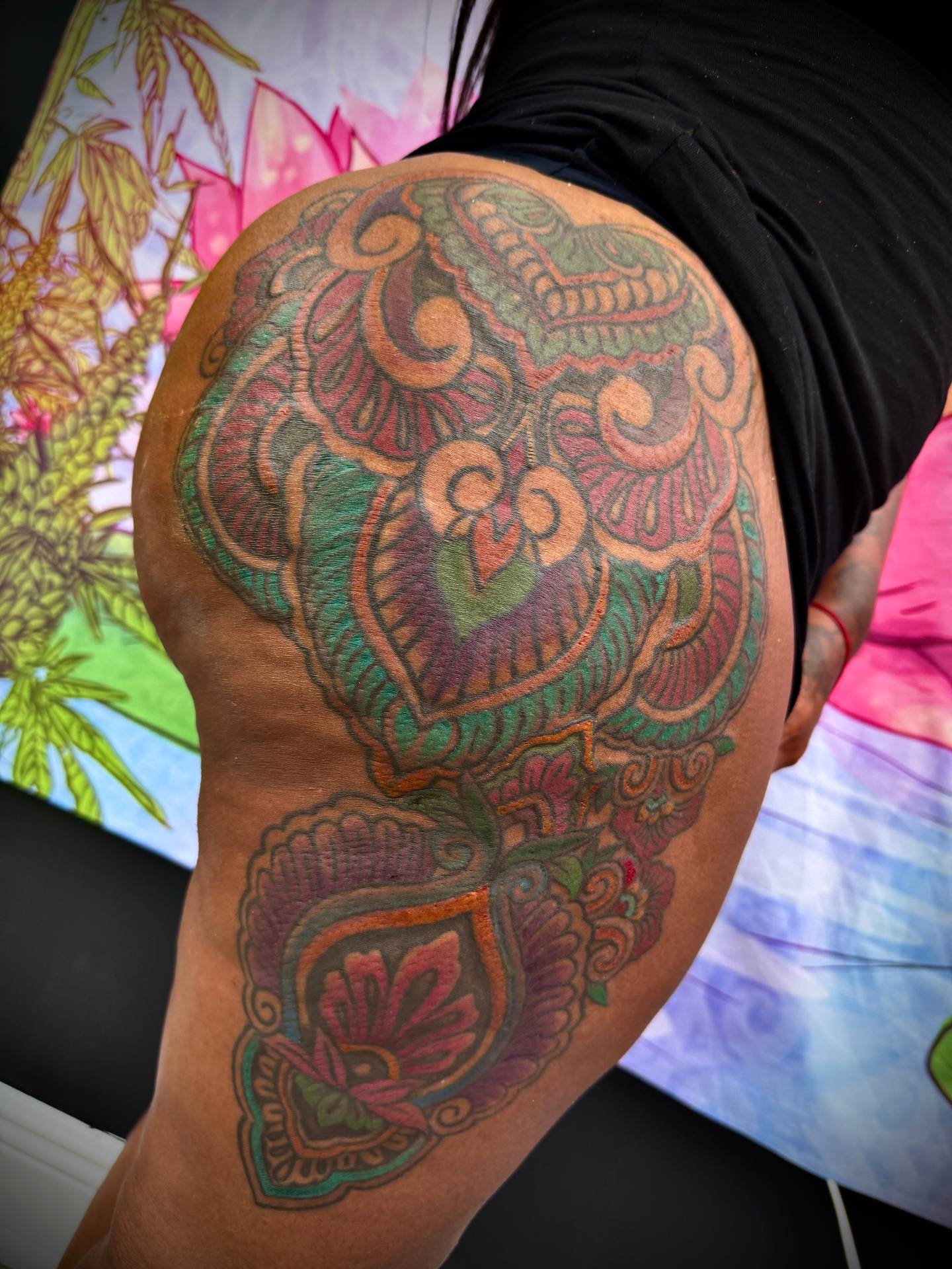 Vibrant color mandala and ornamental tattoo on hip and thigh