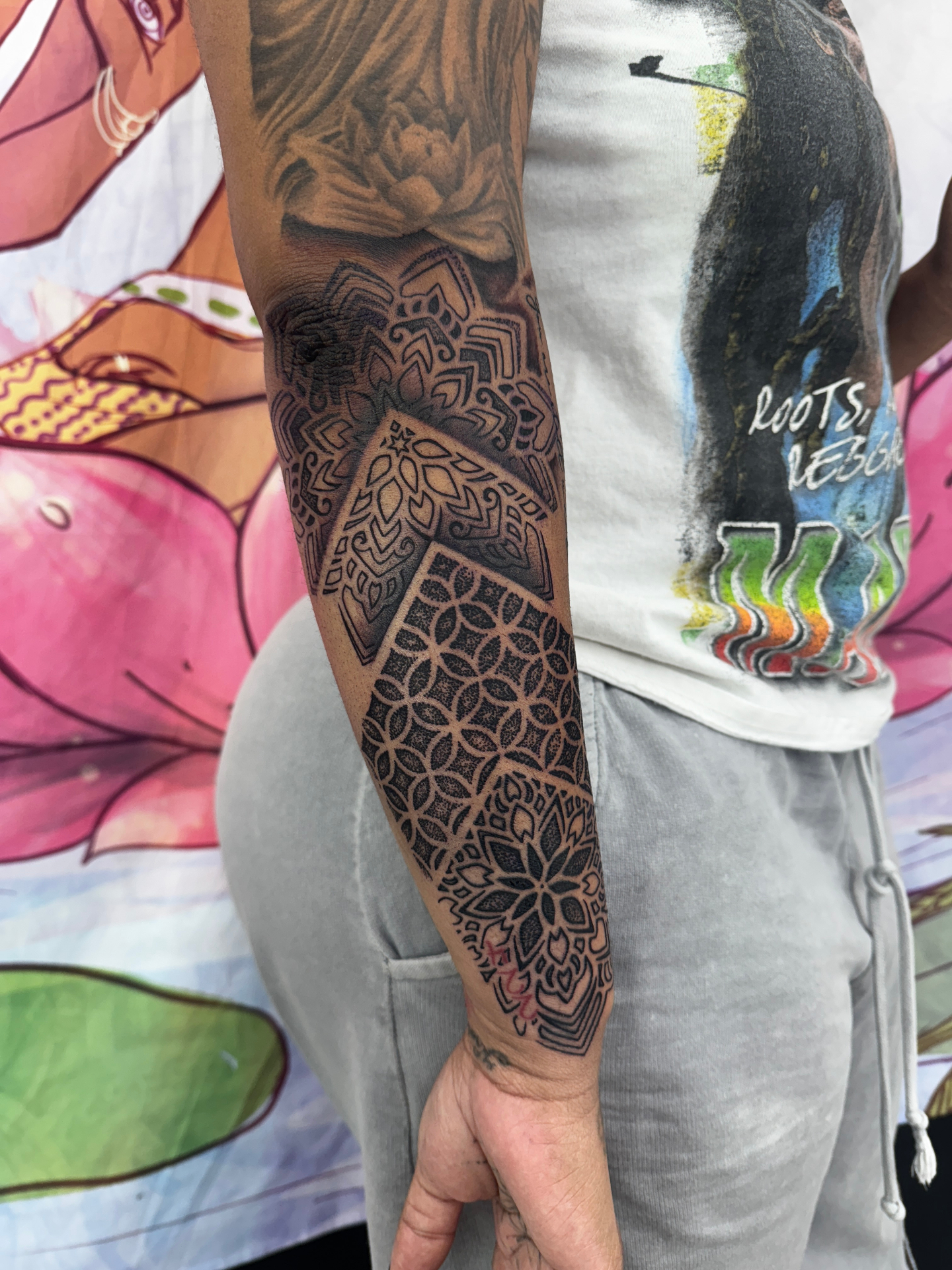 Intricate black dotwork mandala and geometric forearm sleeve tattoo