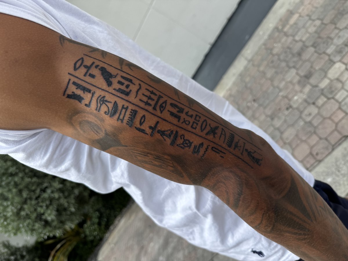 Bold Egyptian hieroglyphs forearm band tattoo